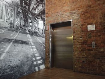an elevator door in a brick building next to a brick wall